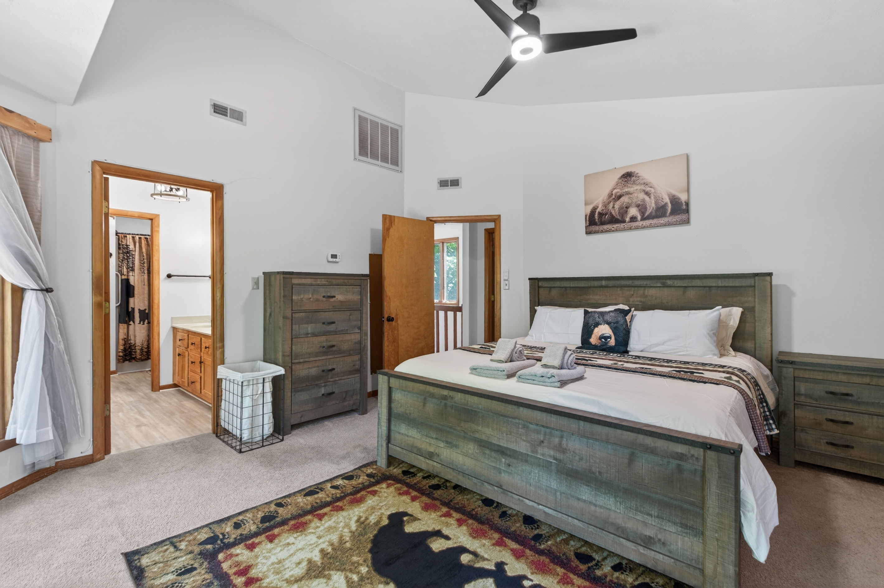 Master Bedroom 1: Rustic charm meets modern comfort with a plush bed and serene forest views!