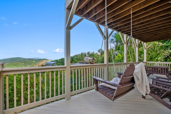 Lower covered deck with porch swing and mountain views