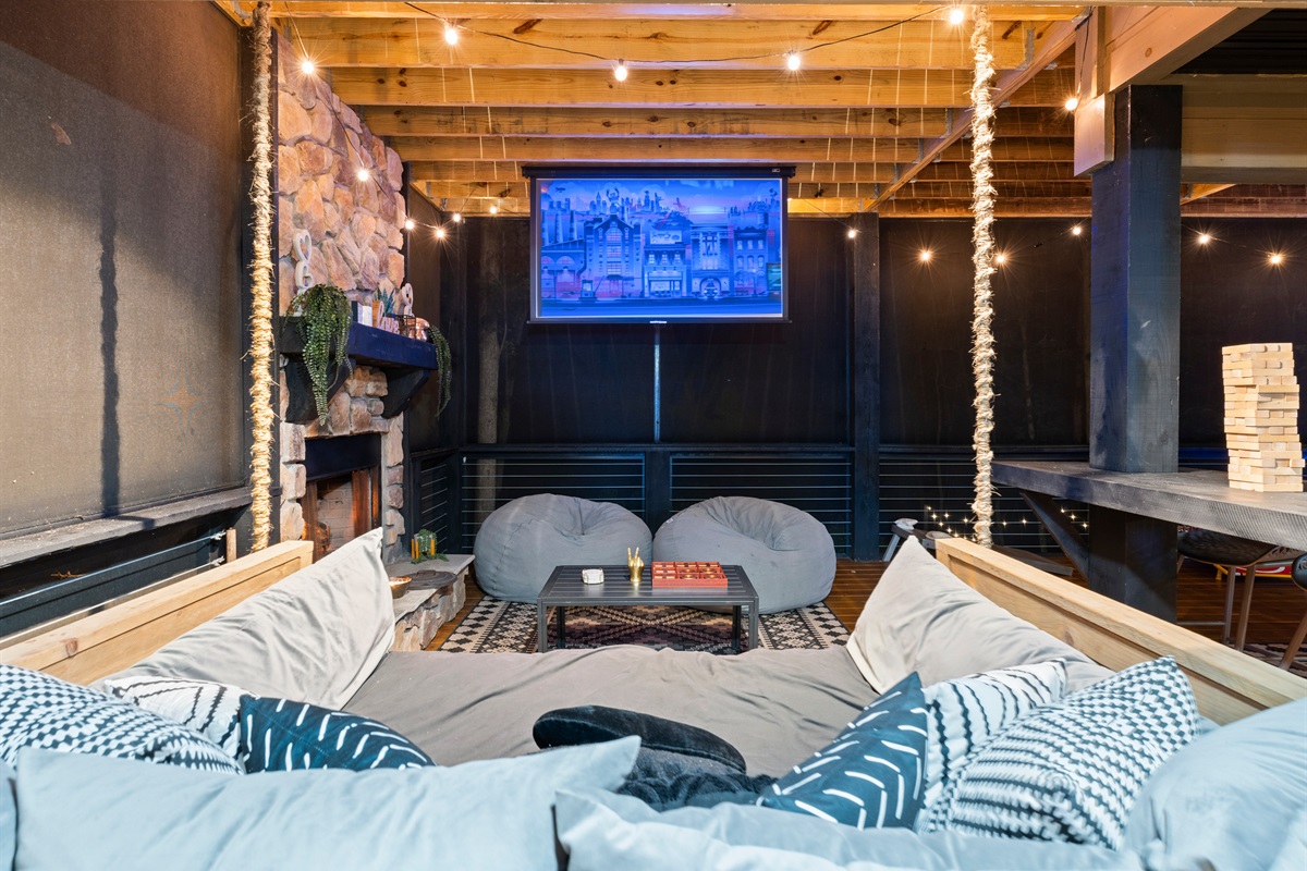 Cozy seating on the queen-size swing-bed and projector make this outdoor spot magical.