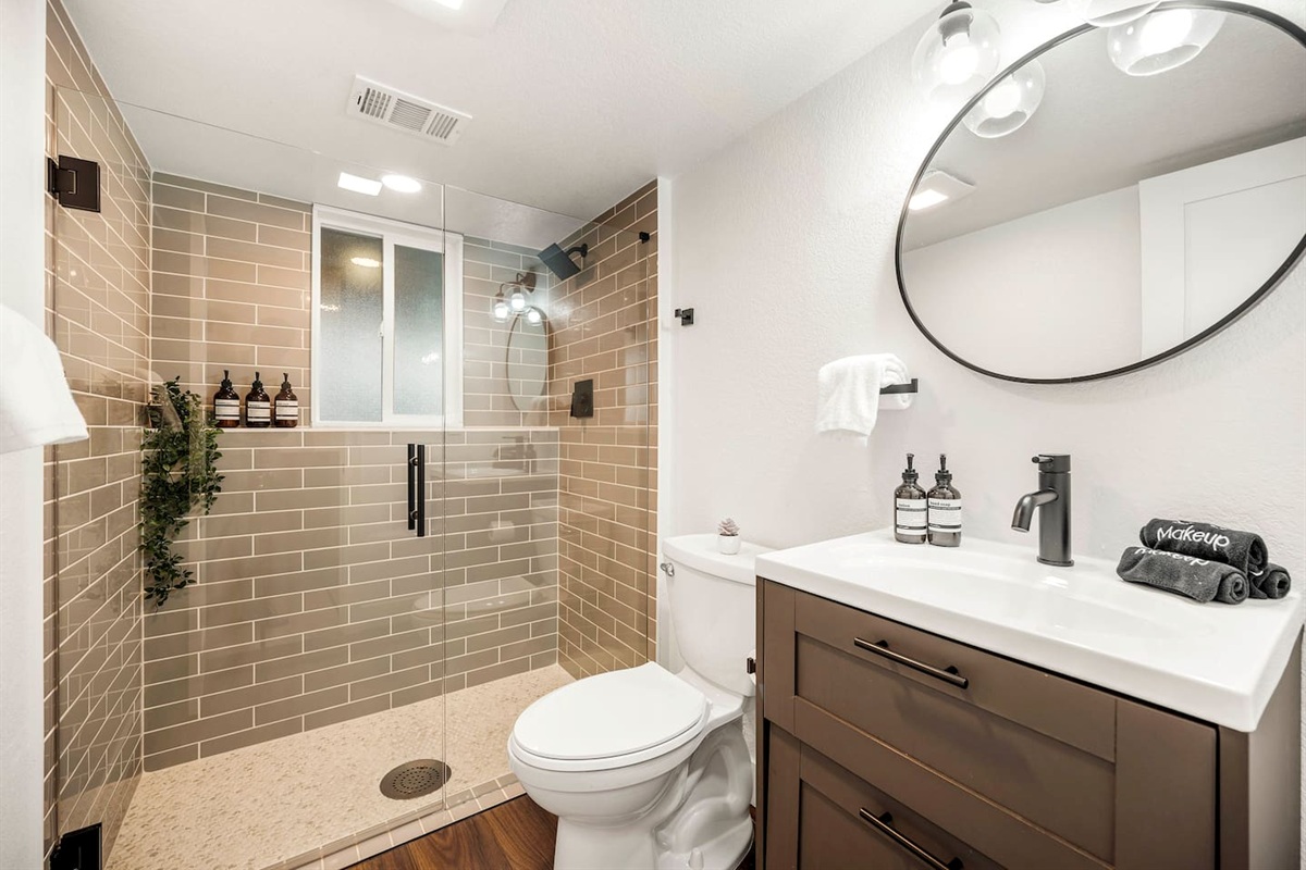 Full bath with sleek walk in shower and fresh guest amenities.