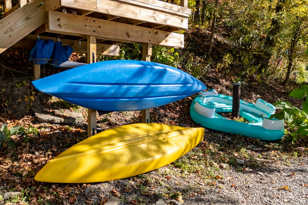 Kayaks and paddleboard ready on the lakeshore — gear for the water.