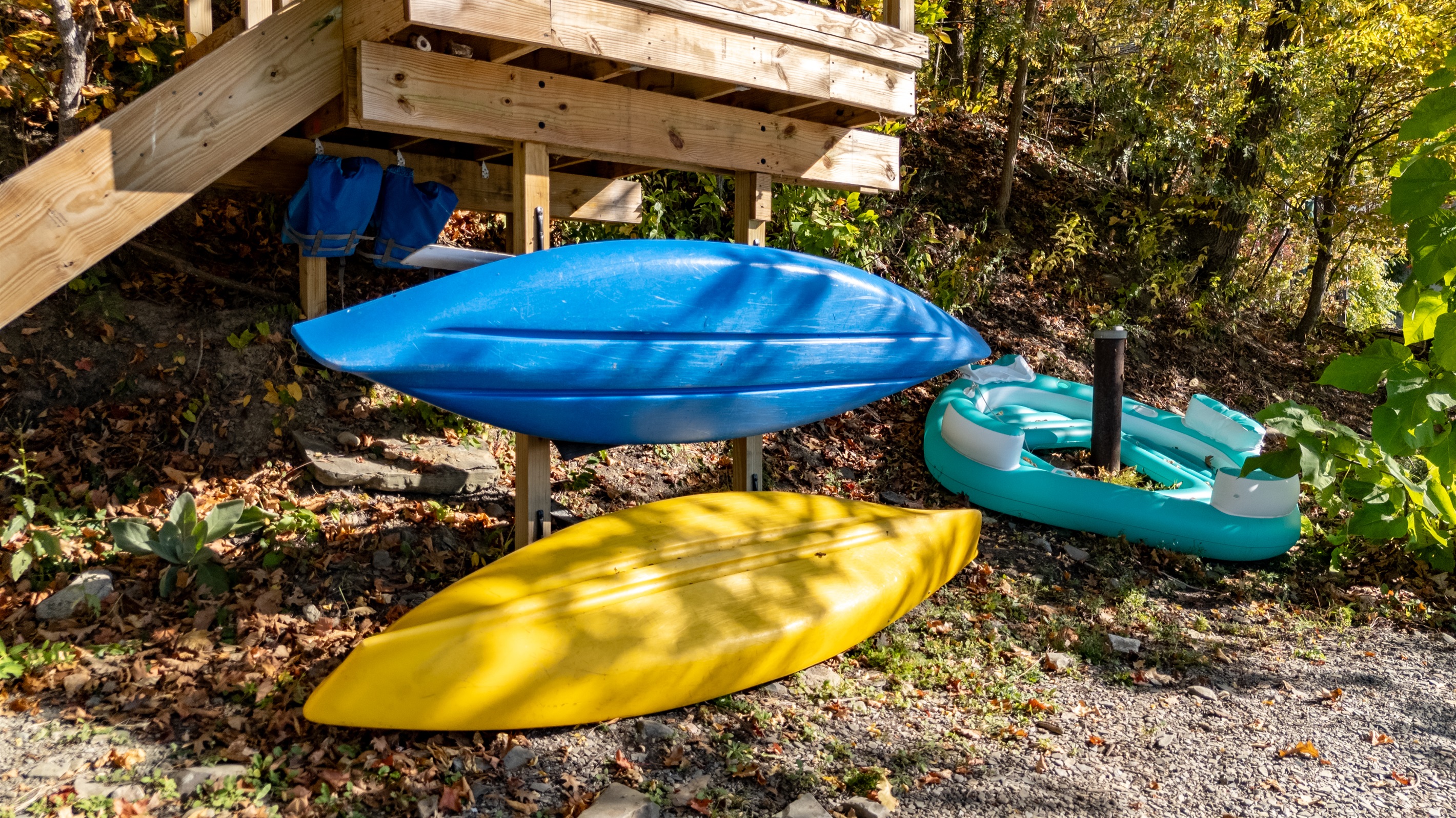 Kayaks and paddleboard ready on the lakeshore — gear for the water.