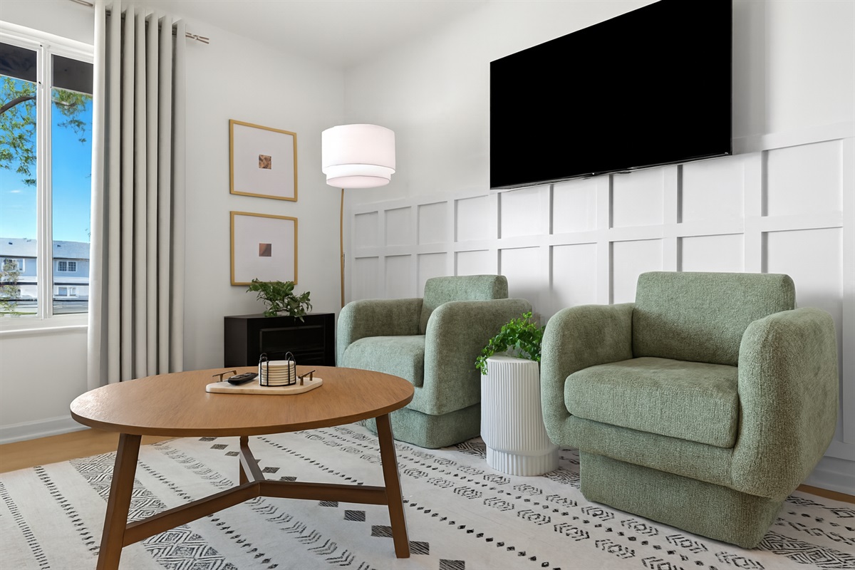 Stylish living room with plush seating, statement wall paneling, and a mounted Smart TV—perfect for relaxing after a day out.