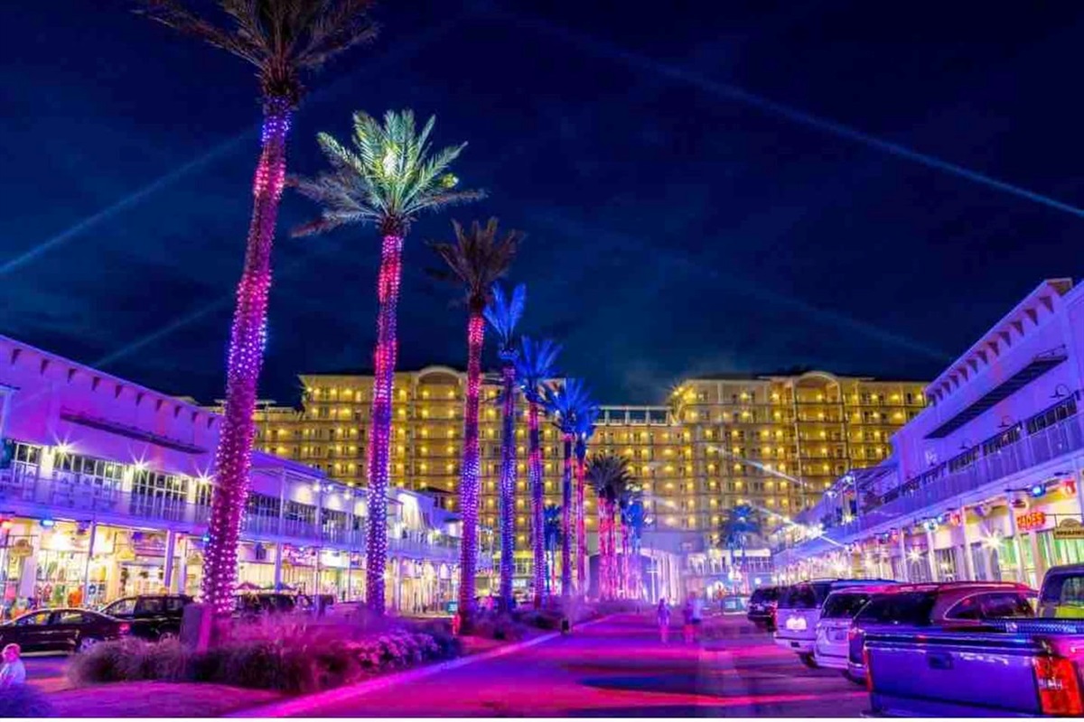 Tropical resort nightlife shines with colorful lights, palm trees, and luxury vibes.