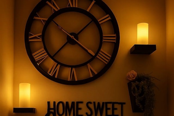 Decorative wall clock and soft candlelight add warmth and a welcoming glow to the hallway space.