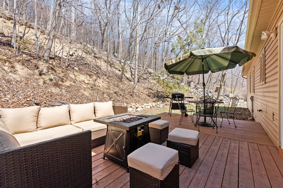 Outdoor seating around the firepit, gas grill and shade under the umbrella