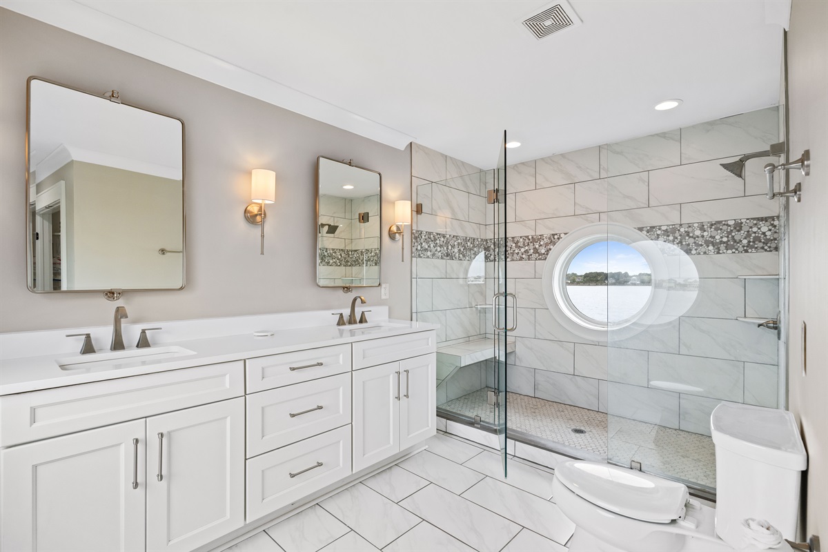 Spa-inspired ensuite bathroom featuring dual vanities and an oversized walk-in glass shower