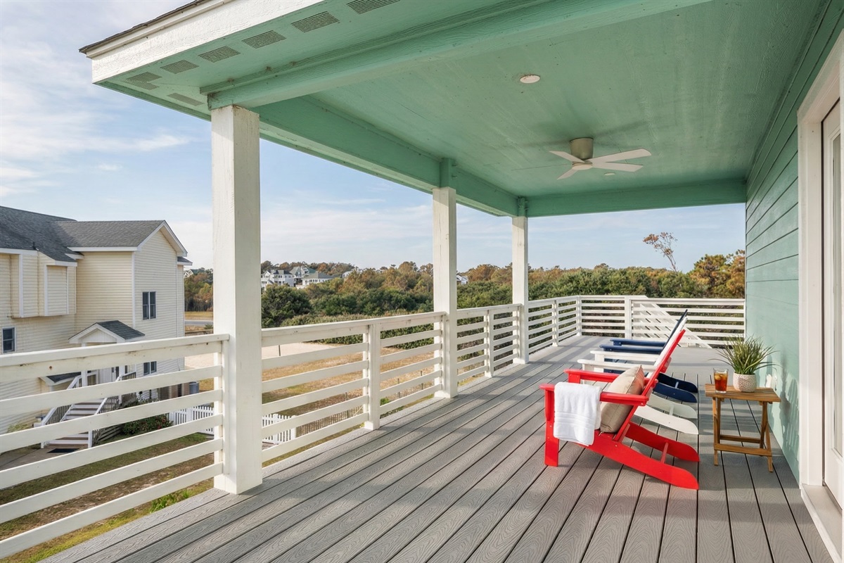 Covered porch with Adirondack chairs—perfect for enjoying the coastal breeze.