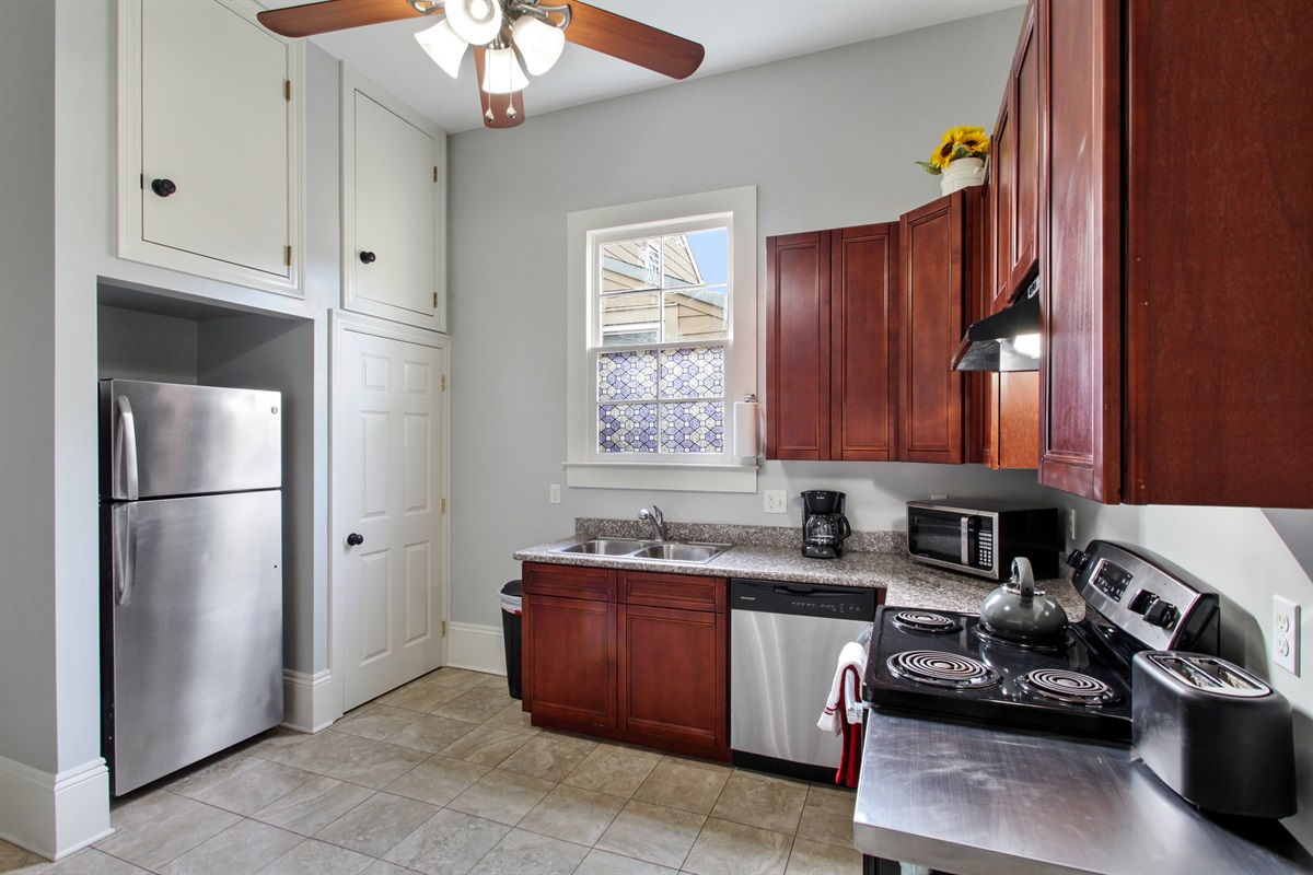 Full kitchen. Stacked laundry machines in closet.