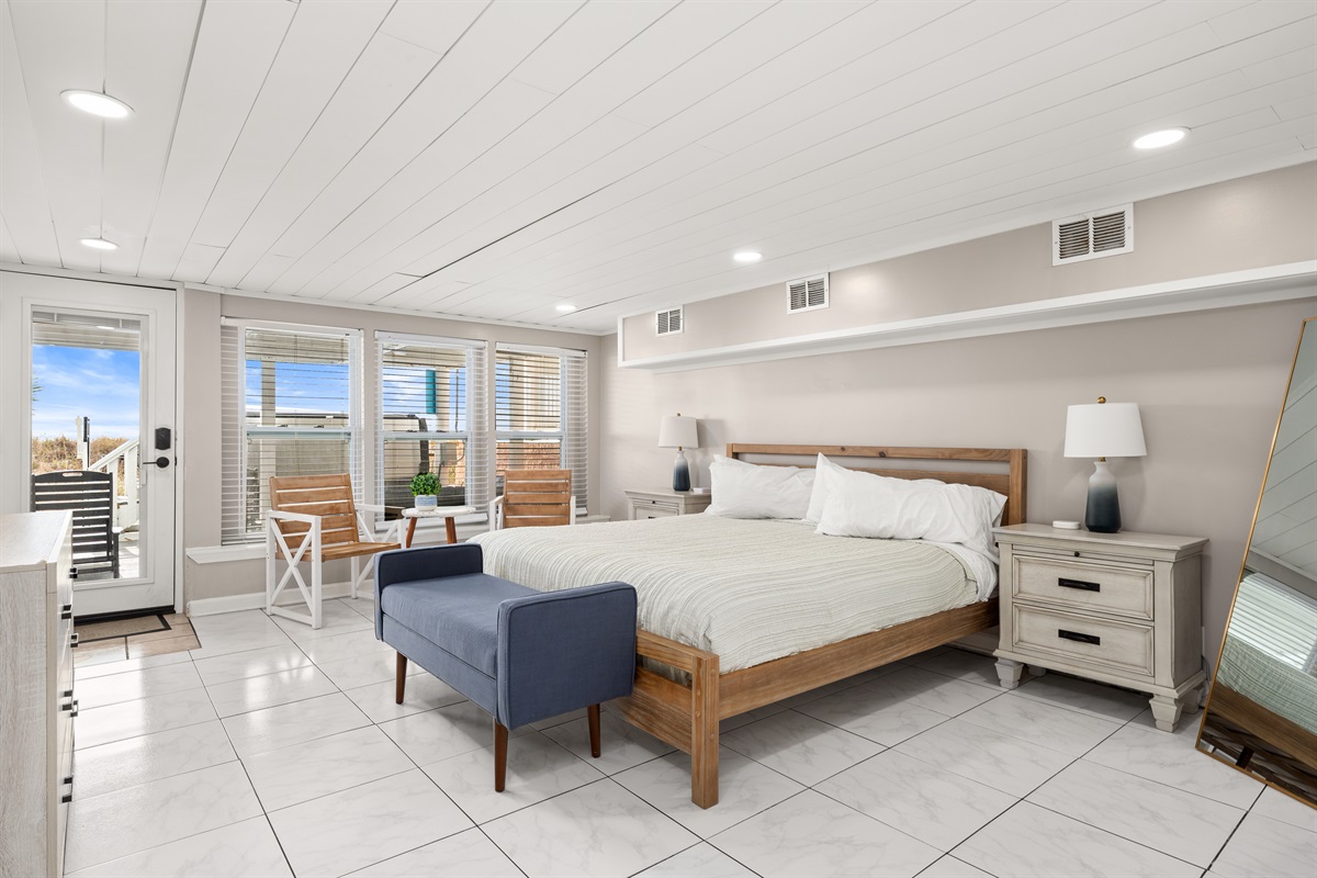 The downstairs beachside west bedroom is equipped with a king bed, seating area, and 55" Roku-enabled TV. Guests may relax after a sun-filled day in the private ensuite full bathroom.