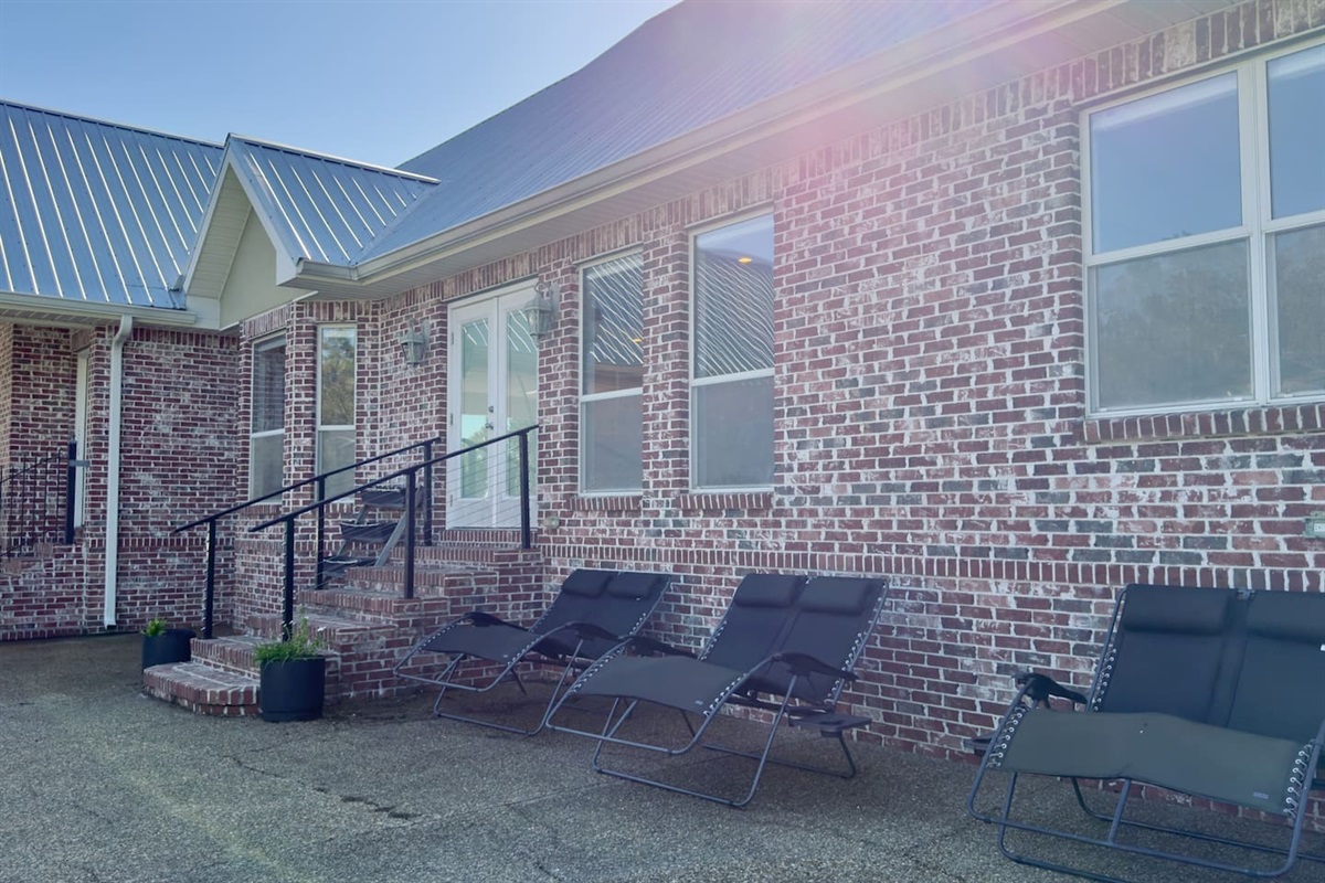 Reclining lounge chairs line the paved patio, offering the perfect spot to soak up the sun.