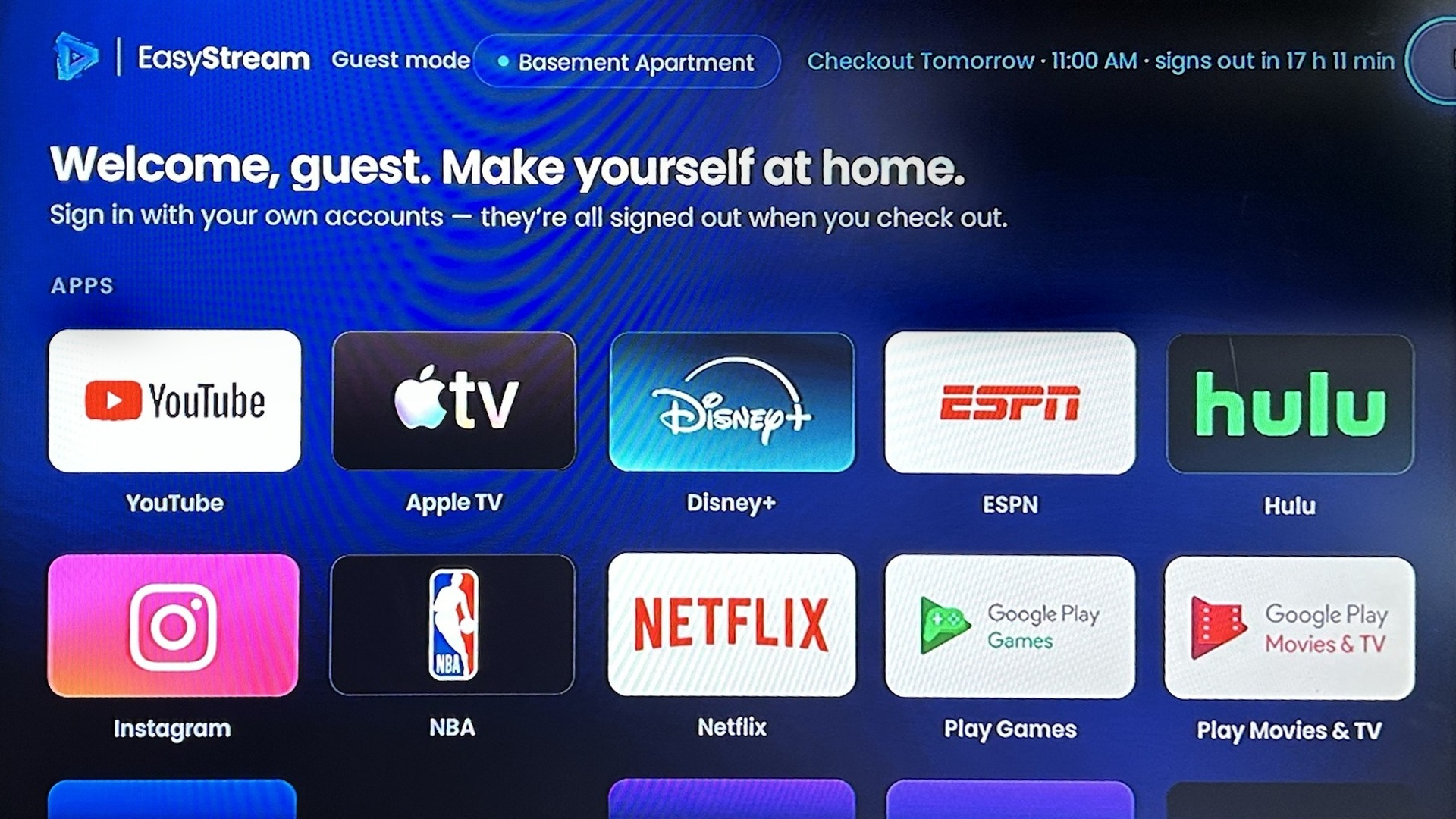Guest Mode is on by default, and the first name in the greeting comes from the guest's OwnerRez booking.  Once a stay is linked, a tag shows when the guest checks out and how long is left, for example Checkout Tomorrow &middot; 11:00 AM &middot; signs out in 17 h 11 min. A Check out button lets a guest sign out early with Check out now, or schedule the sign-out with Set a checkout time. Guests never see the admin screen; it opens only with a button sequence on the remote.